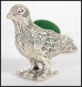 A silver pin cushion in the form of a dove having a baize lined pad cushion
