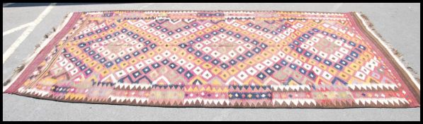 An Afghan / Persian rug of handwoven form having multiple central panel of diamond medallions to the