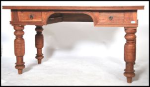 A 20th century hardwood Victorian style desk, central kneehole flanked by drawers raised on turned