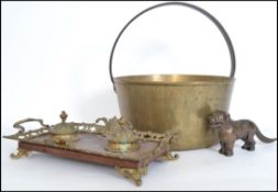A large copper conserve pot with handle atop along with a 20th century brass twin inkwell and a