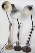 A group of three vintage retro 20th century industrial anglepoise lamps having circular bases with