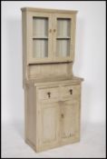 An early 20th century painted shabby chic cottage dresser raised on a plinth base with short drawers