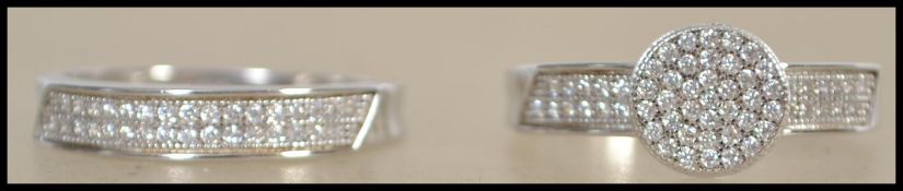 A ladies contemporary silver and cz adorned engagement ring together with a matching half eternity