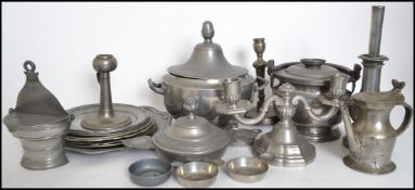 A large collection of pewter to include plates of varying sizes, twin handled bowl, cauldron,