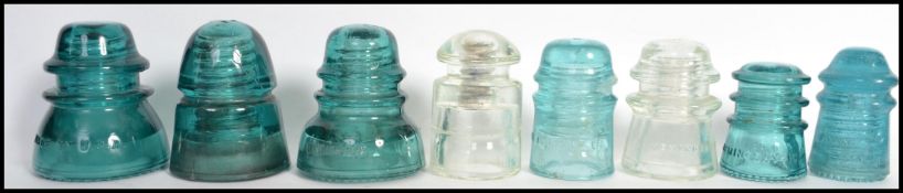 A group of 8 American vintage glass electricity pylon insulators, in green and clear glass, makers