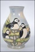 A Moorcroft Pottery Puffin pattern baluster vase decorated with puffins against a mountainous