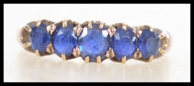 A 9ct gold ring  ( tested ) set with 5 blue sapphire coloured stones. Total weight 2.3g / Size P