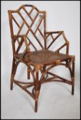 A Regency revival bamboo and cane worked bergere armchair. Raised on bamboo supports with caned seat