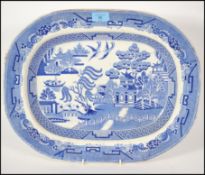 A 19th century Staffordshire blue and white meat platter in the ' Willow ' pattern having transfer