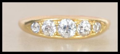 A good 18ct gold and diamond 5 stone ring. Set with old cut diamonds in a rub over setting. The