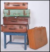 A vintage wooden painted luggage rack raised on squared legs together with a harlequin stack of