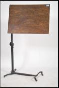 A late Victorian cast metal and mahogany adjustable lecturn reading stand being raised on a 3