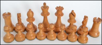 A vintage 20th century carved ebony and box wood chess set held within a wooden box with sliding