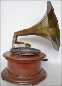 An vintage wooden gramophone with morning glory brass horn, the base of circular form. Complete with