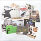 A collection of Banksy and Dismaland related ephemera to include various post cards, Wall and