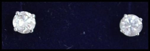 A pair of ladies white gold and diamond stud earrings of approx 50pnts complete in the original