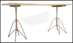 A vintage mid century Industrial plank top refectory table being raised on Industrial cast iron