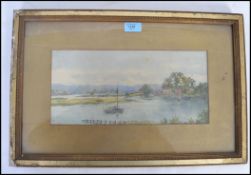 An Edwardian watercolour painting of a sailing boat and estuary scene with shoreside village. Framed