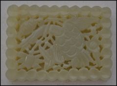 An Oriental jade panel of rectangular form having rounded edges, depicting lotus flowers and birds.