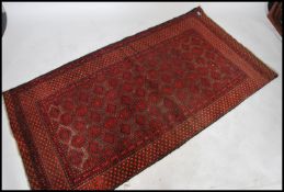 A 20th century Persian Bokhara rug having central