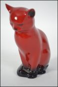 A Royal Doulton Flambe cat figurine being marked to the base with Royal Doulton stamps and