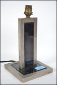 A 1930's Art Deco polished steel and ebonised metal table lamp. Of square form with two tone