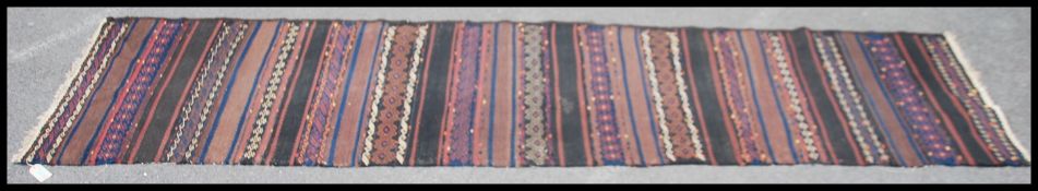 An Afghan / Persian Balouch Kilim runner rug having dark central ground with central spiral