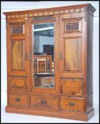 An Edwardian inlaid mahogany triple wardrobe having central mirror door flanked by two inlaid