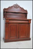A Victorian mahogany chiffonier sideboard being raised on a plinth base with twin doors and carved
