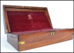 A 19th century mahogany writing slope having a hinged lid with fitted red velvet interior with