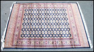 A large Iranian / Persian Bokhara carpet - rug having red ground with geometric decoration and