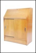 A 1970's teak wood bureau having fall front writing slope with appointed interior over a sliding