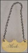 An early to mid 19th century ivory wine bottle label on chain being cartouche shaped with incised