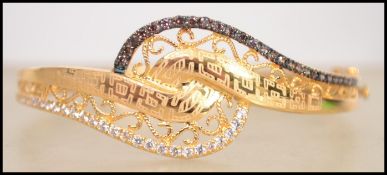 A hallmarked 21ct gold designer bracelet by L'Azurde. Being set with chocolate and white stones with