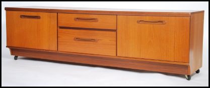 A 1970's teak wood low dresser base sideboard by Portwood being raised on inset plinth base