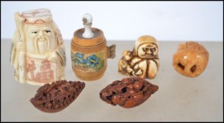 A Chinese bone netsuke figure of an elder with character marks to the base together with resin nut