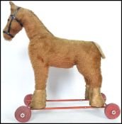 A vintage 20th century plush push along and ride on horse with applied label for International Model