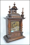 A 20th century oak cased German mantle clock having turned wood columns and finals to top, brass