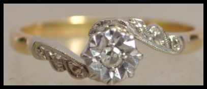 An 18ct gold and platinum diamond solitaire crossover ring with illusion star set diamond in a