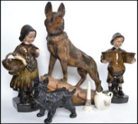 A mixed lot to include a plaster figurine of an Alsatian dog, figure of a boy and girl, cast iron