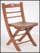 A vintage scratch built home made child's rail back folding chair having an elm panel seat. Measures