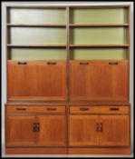 A G-Plan 20th century teak wood set of modular upright wall cabinets. The sectional body with fall
