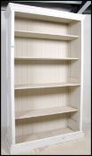 A 20th century shabby chic tall painted window open library bookcase cabinet having a plinth base