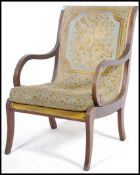A good Regency mahogany revival armchair raised on reeded sabre legs with scroll elbow supports