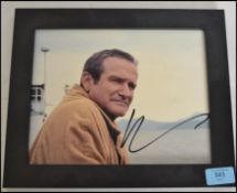 A Robin Williams signed photograph being framed complete with the authentification certificate