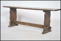 An early 20th century solid oak peg jointed pig refectory bench having a planked top with lyre