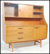 A 1970's retro Danish style highboard sideboard raised on turned legs with cabinets and cupboards