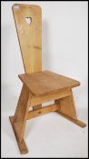 An early 20th century pine Arts and Crafts inspired spinning chair, with splayed supports united