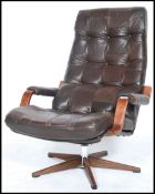 A retro 1970's patchwork leather swivel armchair being raised on a 5 point faux rosewood base with