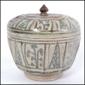 A believed 16th / 17th century Oriental stoneware lidded jar with finial atop. Measures 13cms wide.